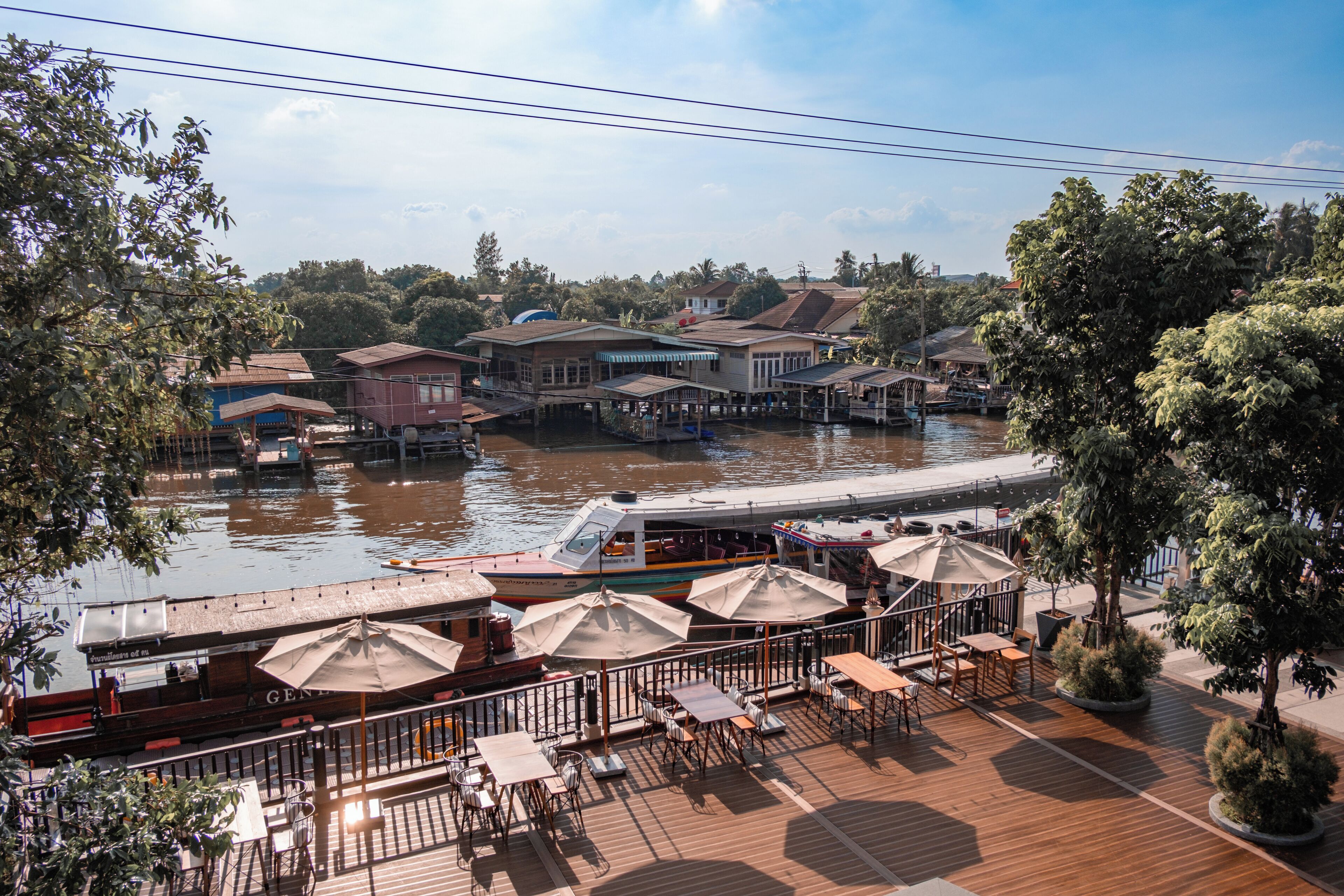 A riverside restaurant with outdoor seating and a view of the river.