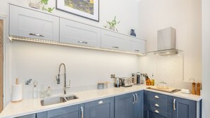 A modern kitchen with a sink, countertop, cabinets, and a range hood. - Derwent House Apartments - Harwood - UK46786 (Scarborough)