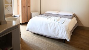 Un dormitorio moderno con cama, mesita de noche y armario.