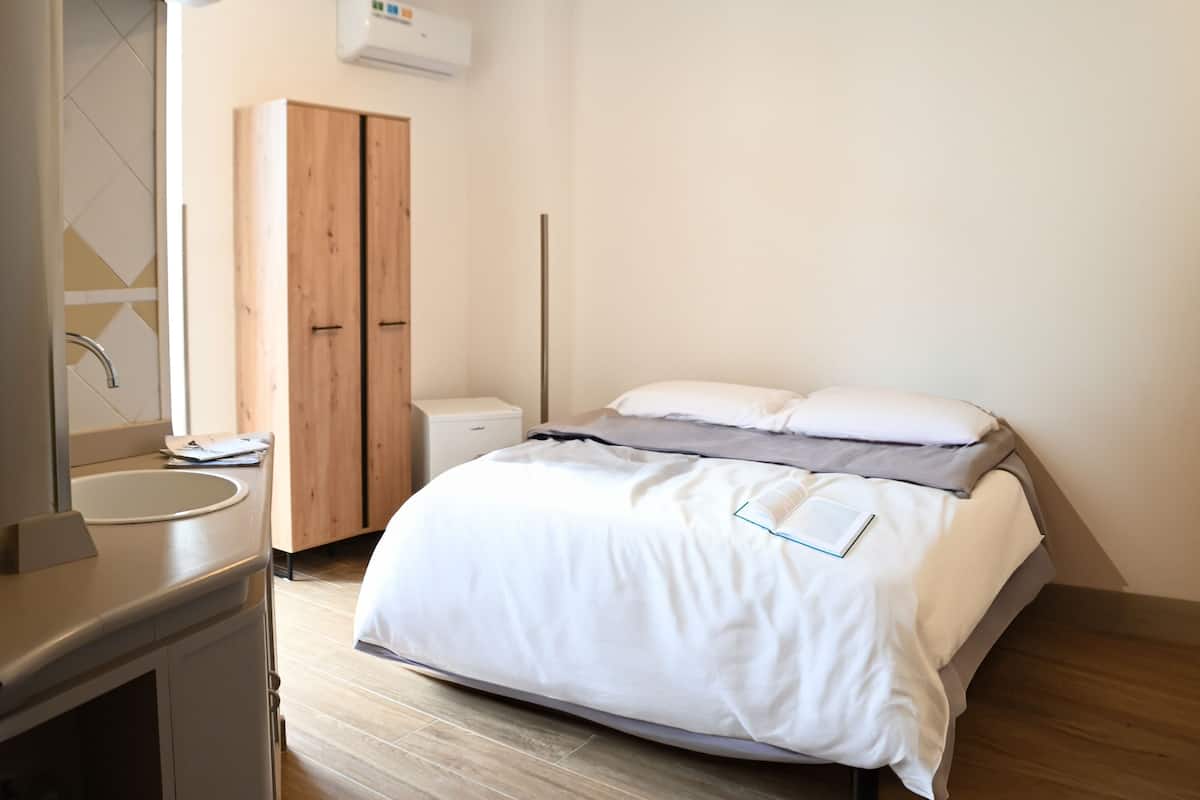 A modern bedroom with a bed, bedside table, and a wardrobe.