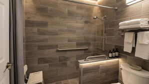 Un baño moderno con ducha, inodoro y perchero.