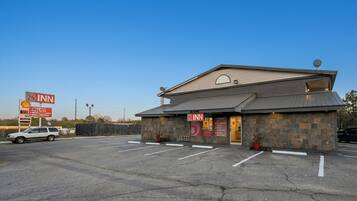 A 3-story building with a 8 Inn sign, a Shell gas station, and a parking lot.