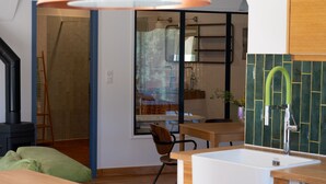 A modern kitchen with a gas stove, wooden cabinets, and a large window. - Appartement T3 bas de Villa (Vero)