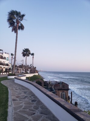 A coastal walkway with palm trees, a stone path, and a wooden structure by the sea. - Beautiful oceanfront villa - large terrace, bbq, fire pit, pool, jacuzzi, beach (Primo Tapia)