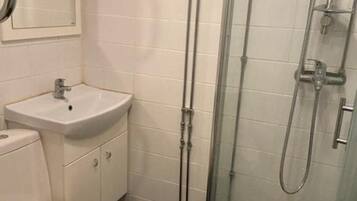Appartement | Badkamer | Een douche, handdoeken, toiletpapier
