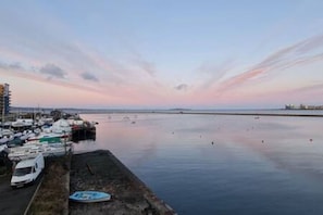 A marina with boats docked, a calm sea, and a clear sky. - Calming Sea View City Apartment (Edinburgh)
