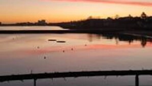 A calm body of water reflecting the sky during sunset. - Calming Sea View City Apartment (Edinburgh)