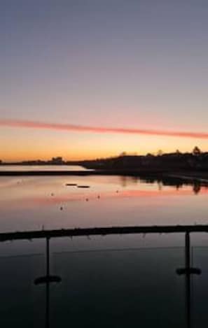 A calm body of water reflecting the sky during sunset. - Calming Sea View City Apartment (Edinburgh)