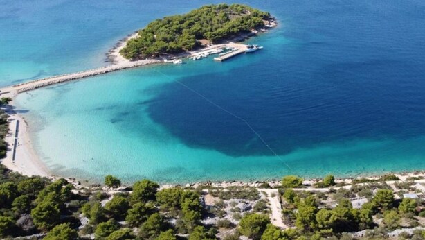 An aerial view of a small island with a clear turquoise sea, surrounded by a rocky coastline. - Holiday Home Mirta - Three Bedroom Holiday Home with terrace (Murter)