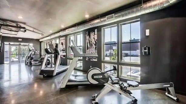 Et fitnessrum med løbebånd, crosstrainere og styrkemaskiner.