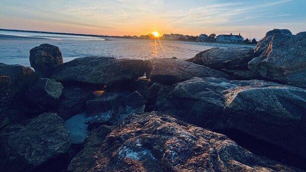 A rocky shoreline with a sunset in the background. - Sea Bisquit Cottage by the Ocean (Scarborough)