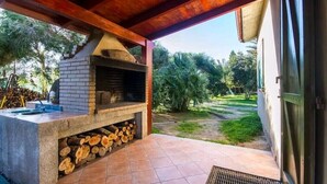 An outdoor kitchen area with a brick oven, a sink, and a fire pit. - Cottage surrounded by greenery ideal for families (SANT'ANTIOCO)