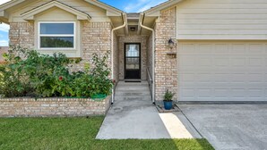 A residential house with a brick exterior, a garage door, and a front entrance. - Cozy 2 Bdrm Home in Quiet NBHD + Pets Allowed  (Montgomery)