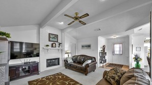 A spacious living room with a flat-screen TV, leather sofa, and a fireplace. - Cozy 2 Bdrm Home in Quiet NBHD + Pets Allowed  (Montgomery)