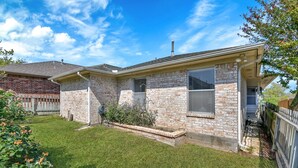 A two-story house with a brick facade, a front porch, and a well-maintained lawn. - Cozy 2 Bdrm Home in Quiet NBHD + Pets Allowed  (Montgomery)
