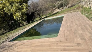 A swimming pool with a wooden deck. - Casa Rural (Candeleda)