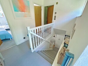 A staircase with white balusters, a radiator, and a door leading to another room.