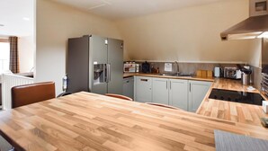 A compact kitchen with a refrigerator, microwave, sink, and wooden countertop. - 4 bedroom accommodation in Balmaha (Balmaha)