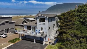 Un edificio de dos pisos con balcón, garaje y vista al océano.