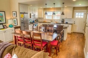 Una cocina amplia con armarios de madera, una isla central e iluminación colgante.