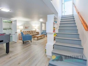 A spacious living area with a staircase leading to an upper floor.