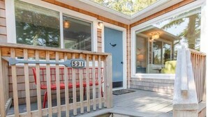 Une terrasse en bois avec un panneau portant le numéro « 591 » et un banc.
