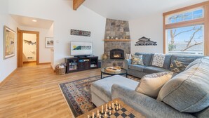 A living room with a fireplace, a sofa, a coffee table, and a TV. - Coastal View by Manzanita Beach Getaway: Ocean Views, Dog-Friendly & Great Deck (Neahkahnie)