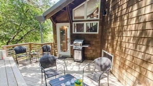 Une terrasse avec coin salon extérieur et espace barbecue.
