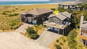 Una proprietà costiera con una casa moderna, completa di un'ampia terrazza e vista sull'oceano.