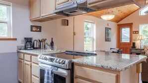 Une cuisine avec des meubles en bois, une cuisinière en acier inoxydable et un plan de travail en granit.