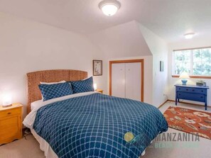 A bedroom with a bed, nightstands, a dresser, a window, and a door. - Simply Adrift by Manzanita Beach Getaway: 4 Blocks to Beach & 1 to Downtown (Manzanita)