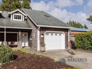 A single-story house with a garage, a covered porch, and a small front yard with mulch and shrubs. - Simply Adrift by Manzanita Beach Getaway: 4 Blocks to Beach & 1 to Downtown (Manzanita)