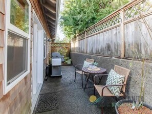 A small patio with a wooden fence, a table with chairs, and a grill. - Simply Adrift by Manzanita Beach Getaway: 4 Blocks to Beach & 1 to Downtown (Manzanita)