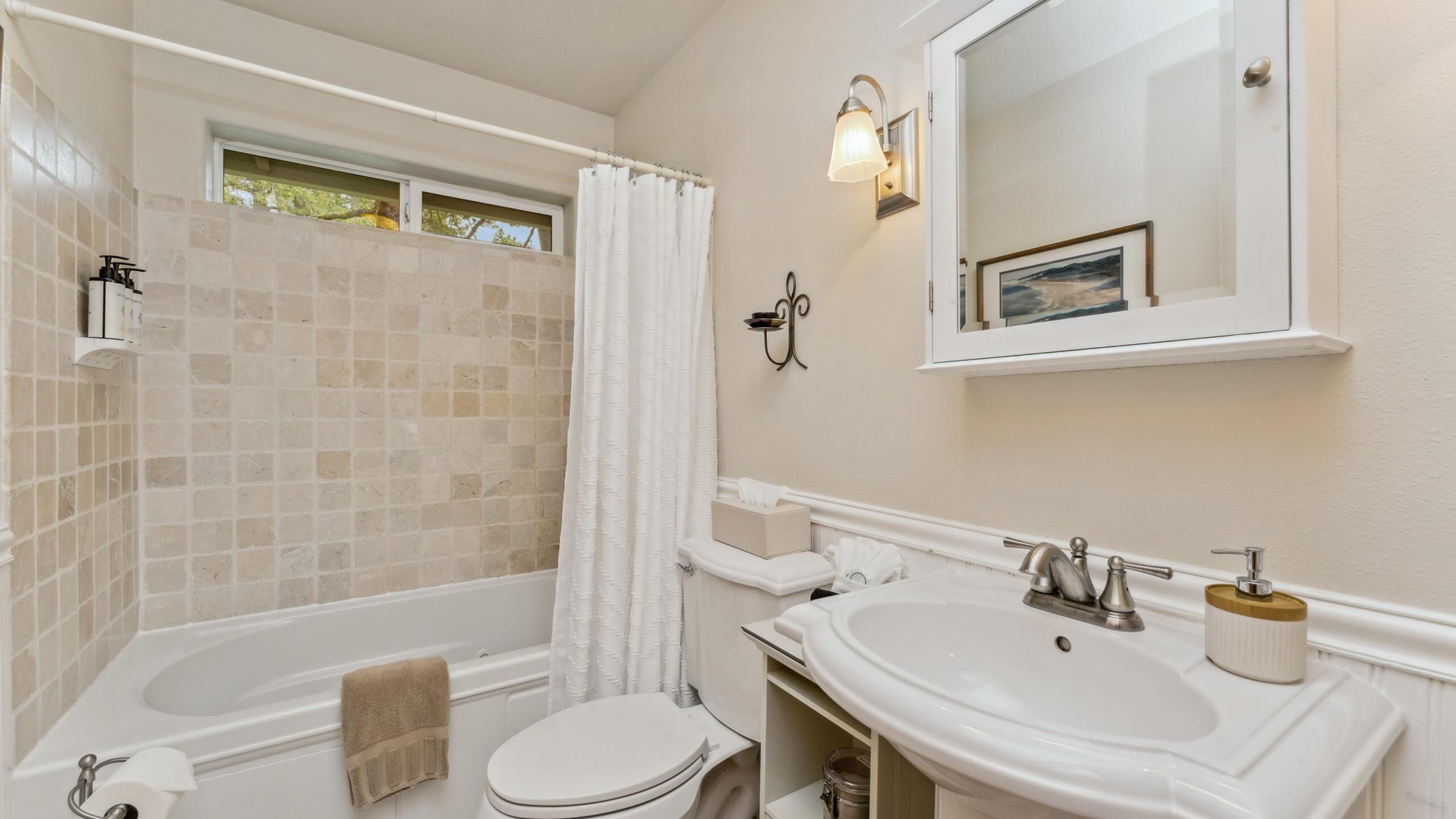 A bathroom with a bathtub, toilet, and sink.
