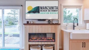 Moderni keittiö, jossa on takka, kyltti, jossa lukee ”Manzanita Beach Getaway”, ja näkymä ulos.