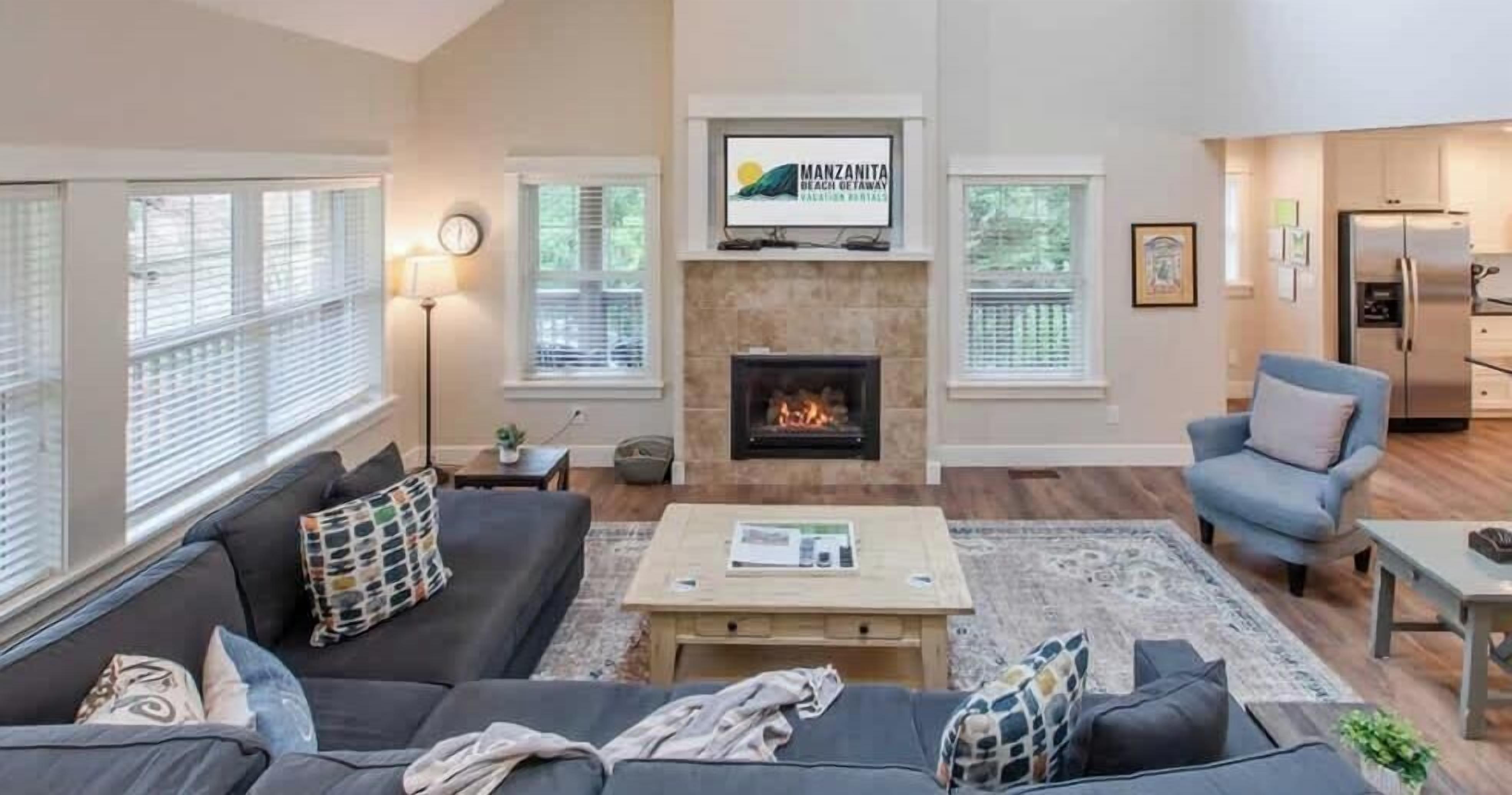A living room with a fireplace, a television mounted above it, a sofa, a coffee table, and a chair.