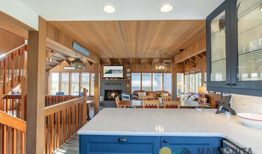 A spacious kitchen with wooden accents, a central island, and a dining area with a fireplace.