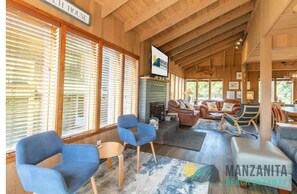 Un vaste espace de vie agrémenté de poutres en bois, d’une cheminée et de sièges confortables.