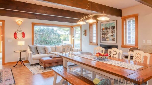 A spacious living room with a wooden dining table, white chairs, a sofa, and a fireplace. - Sea Star by Manzanita Beach Getaway: 3BR Family & Dog-Friendly Near Beach (Manzanita)