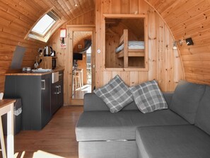 A cozy cabin interior with a kitchenette, a sofa with plaid cushions, and a loft bed. - 2 bedroom accommodation in Corney, near Millom (Corney, near Millom)