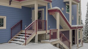 Ein mehrstöckiges Gebäude mit blauer Fassade, einer roten und beigen Treppe und einem Schild, das eine 'Tomahawk Suite' anzeigt.