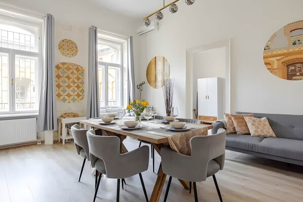 Un comedor moderno con una mesa preparada para cuatro personas, rodeada de sillas grises.