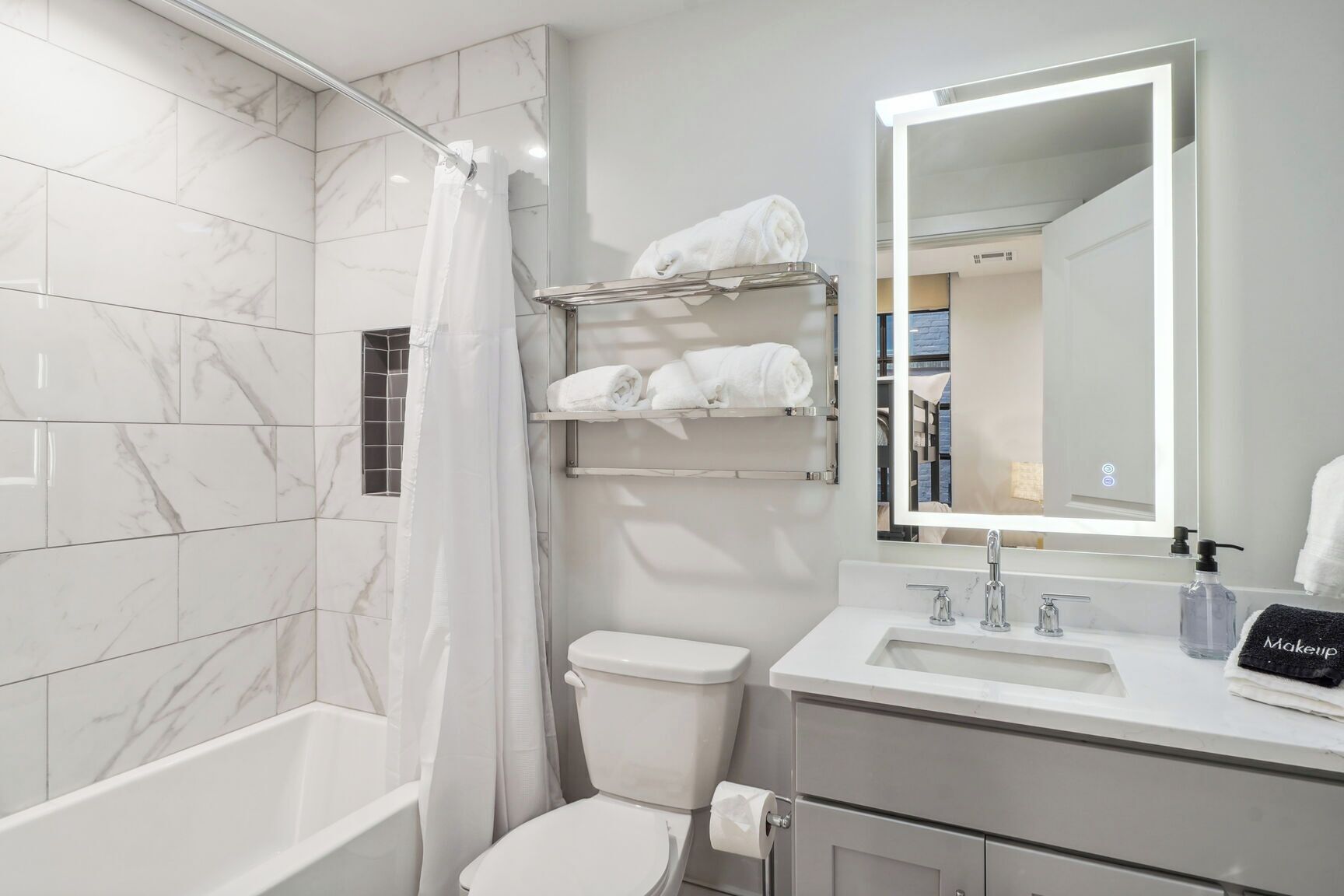 A modern bathroom with a shower, toilet, and vanity.