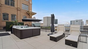 A rooftop terrace with a hot tub, lounge chairs, and a pergola. - The Eleanor 5BD/4B w Two Balconies, 8th Floor (New Orleans)