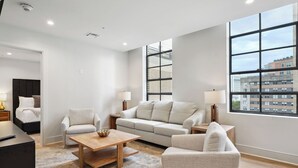 A modern living room with a sofa, armchairs, a coffee table, and a bed. - The Eleanor 5BD/3B - 4 King Bedrooms & F/F Bunkbed (New Orleans)