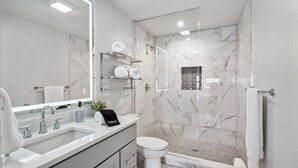 A modern bathroom with a large mirror, two sinks, a toilet, and a shower area. - The Eleanor 10BD/10B, All King Bedrooms w Ensuites (New Orleans)