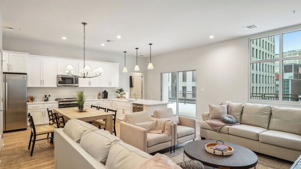 A modern apartment with a kitchen, dining area, and living room.