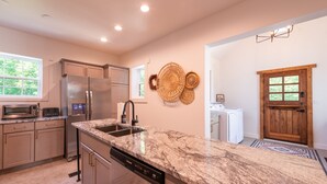 Una cocina moderna con encimeras de granito, electrodomésticos de acero inoxidable y lavavajillas integrado.
