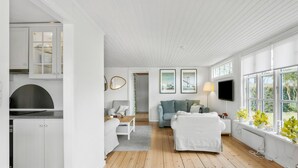 En modern inredning med kök, vardagsrum och matplats.