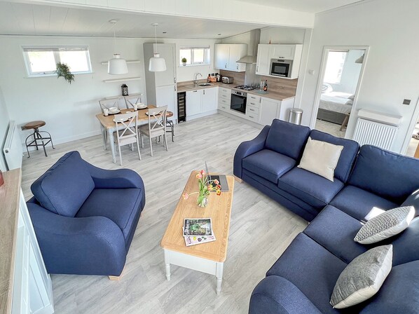 A modern living room with a sofa, coffee table, and dining area.
